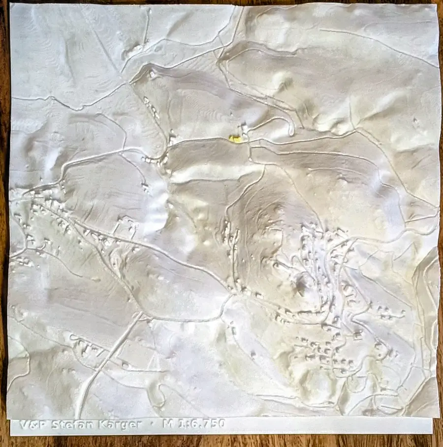 Draufsicht auf das Ortsrelief, Straßen und Bäche als feine Rillen im Gelände